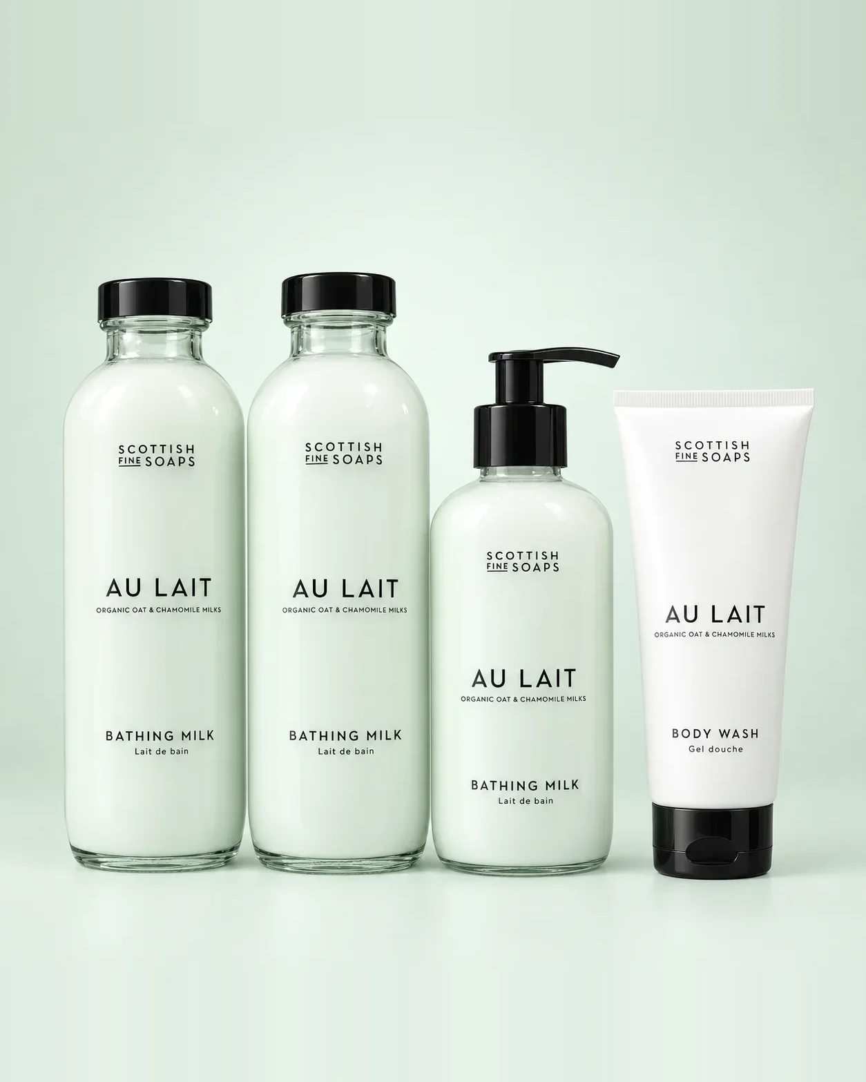 Scottish Fine Soaps Au Lait bathing milk, pump bottle and tube on a soft mint background