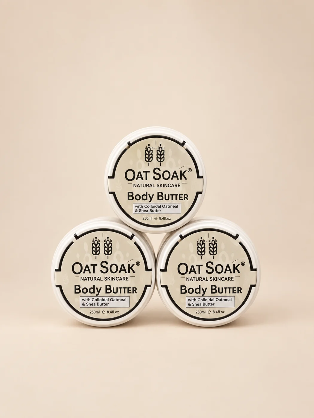 Oat Soak body butter tins stacked on a soft oat background